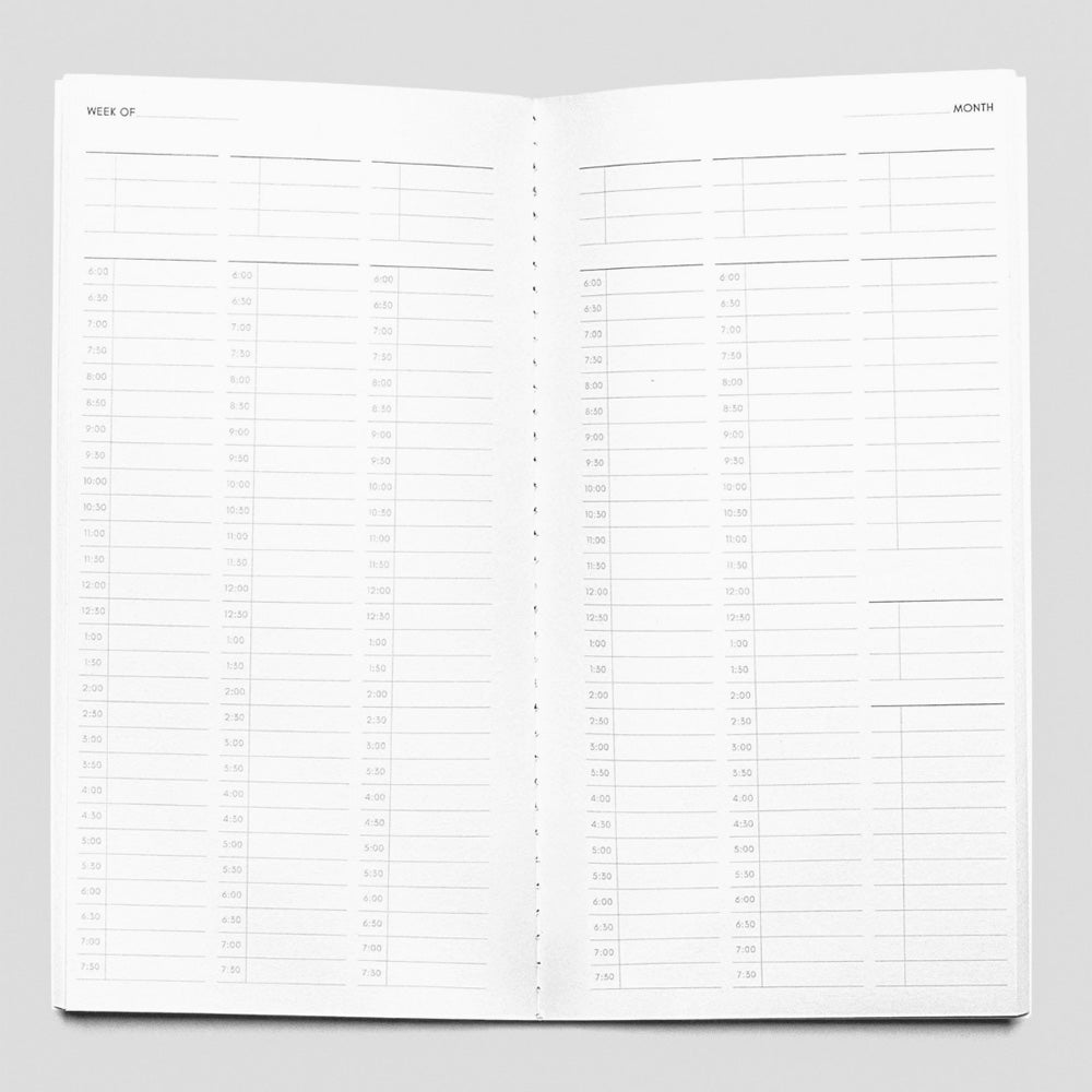 Open planner with grid layout on a gray background