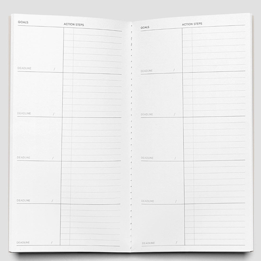 Open planner with goal and action steps sections on a white background