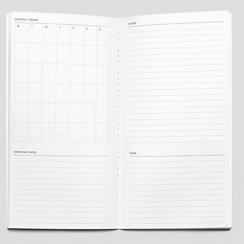 Open planner with monthly calendar and notes section on a gray background