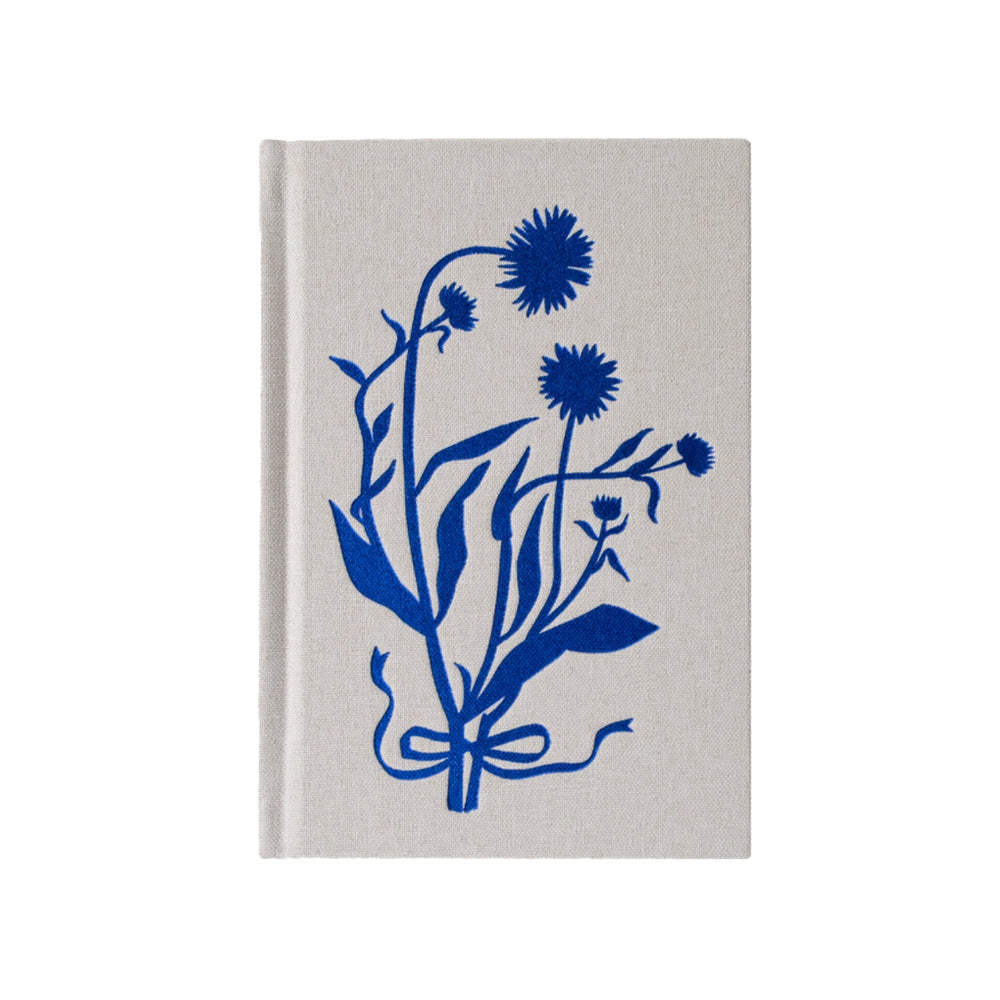 White hardbound journal with a blue silhouette of flowers wrapped in ribbon.