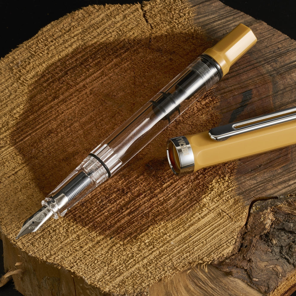 Fountain pen and lighter set on a wooden surface with a dark background