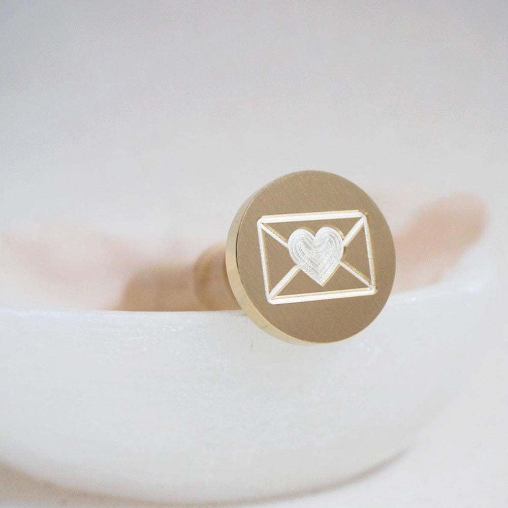 Gold wax seal of a envelope with a heart in the middle