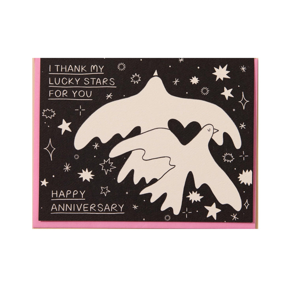 Greeting card with two doves holding a heart and starry night design, text 'I thank my lucky stars for you. Happy Anniversary'.