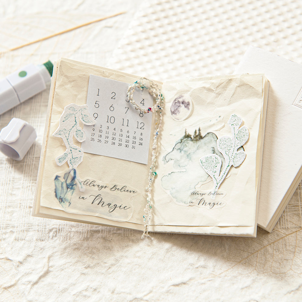 Open notebook with decorative stickers and a calendar on a textured surface