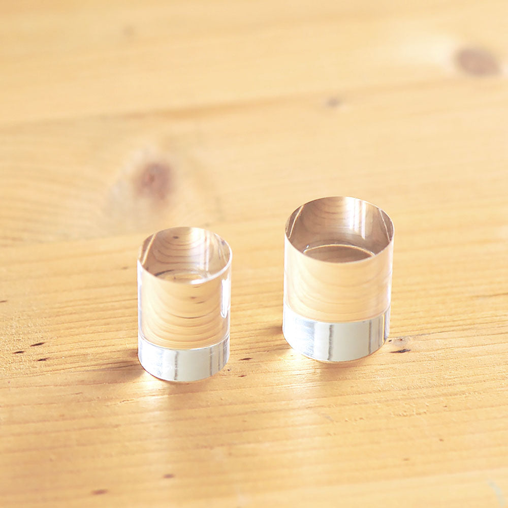 Two acrylic cylinder blocks for clear stamps on a wooden surface