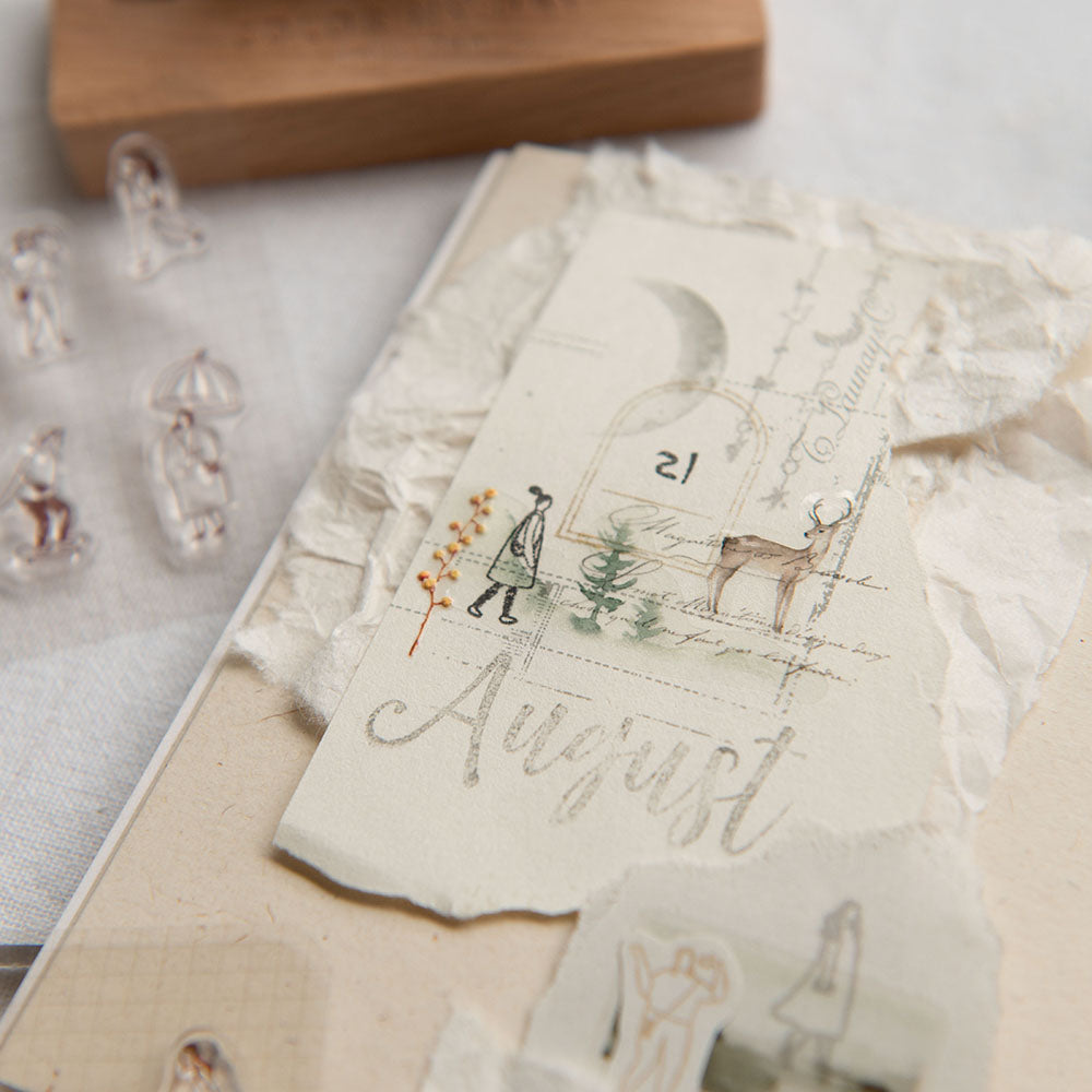 Vintage-style card with illustrations and 'August' text on a textured surface.