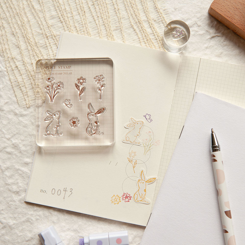 Clear stamp set with animal designs on a notebook with a pen next to it.