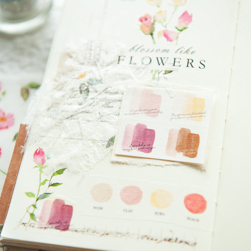 Notebook with floral design and color swatches on a marble surface