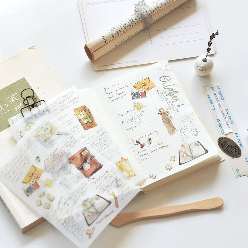 Open book with decorative stickers on a white surface