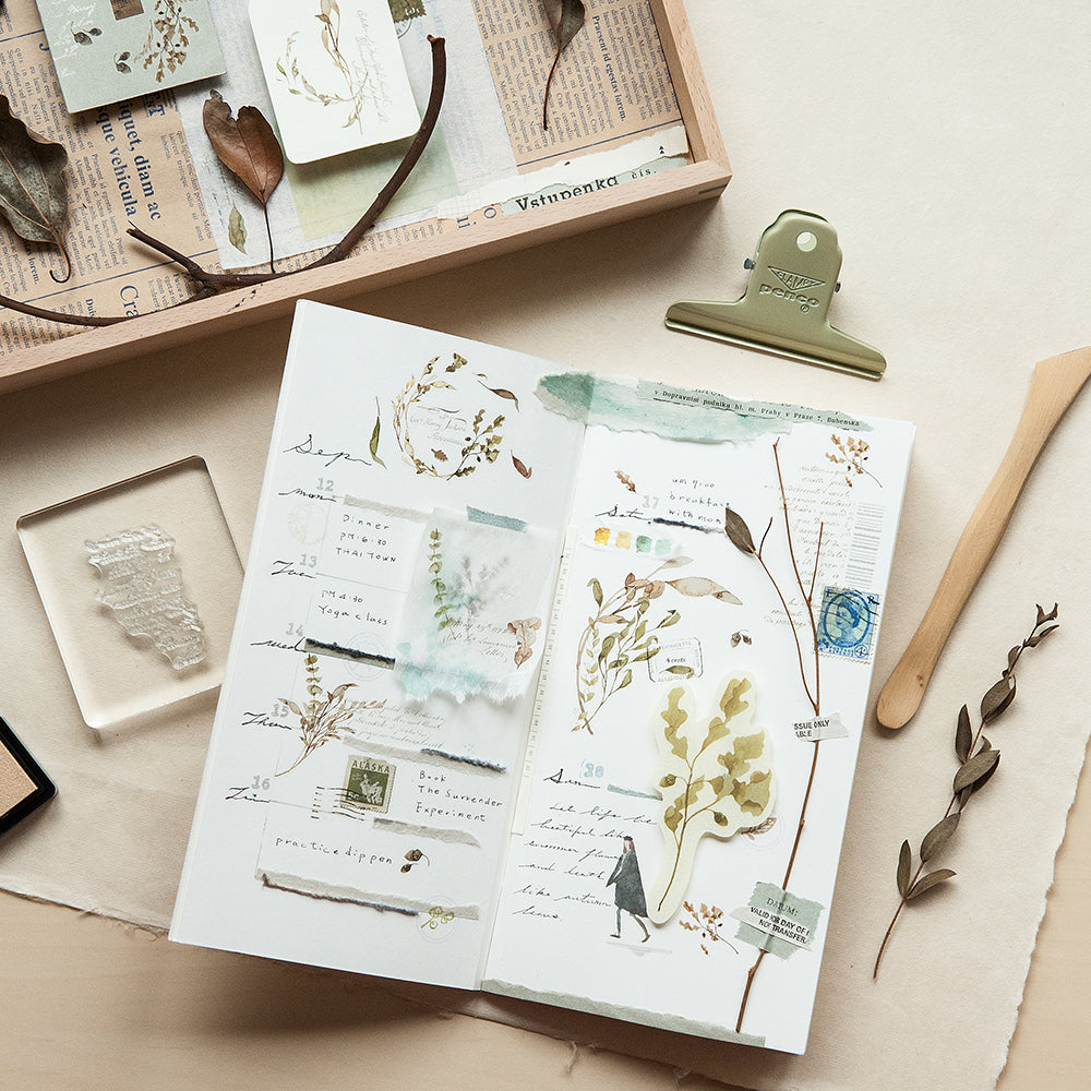 Sheet of decorative paper with nature-themed designs on a light wooden surface.