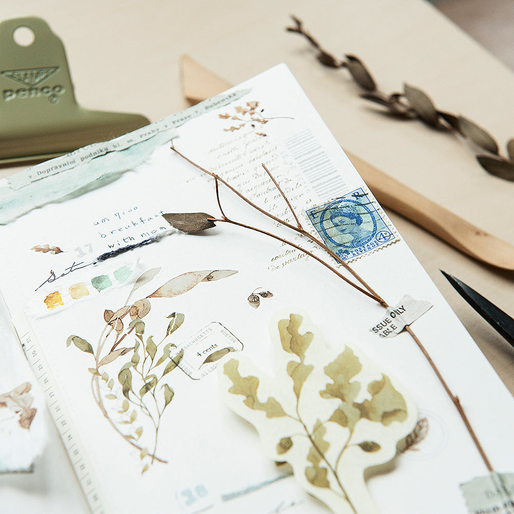 Stationery set with floral stickers and a stamp on a desk
