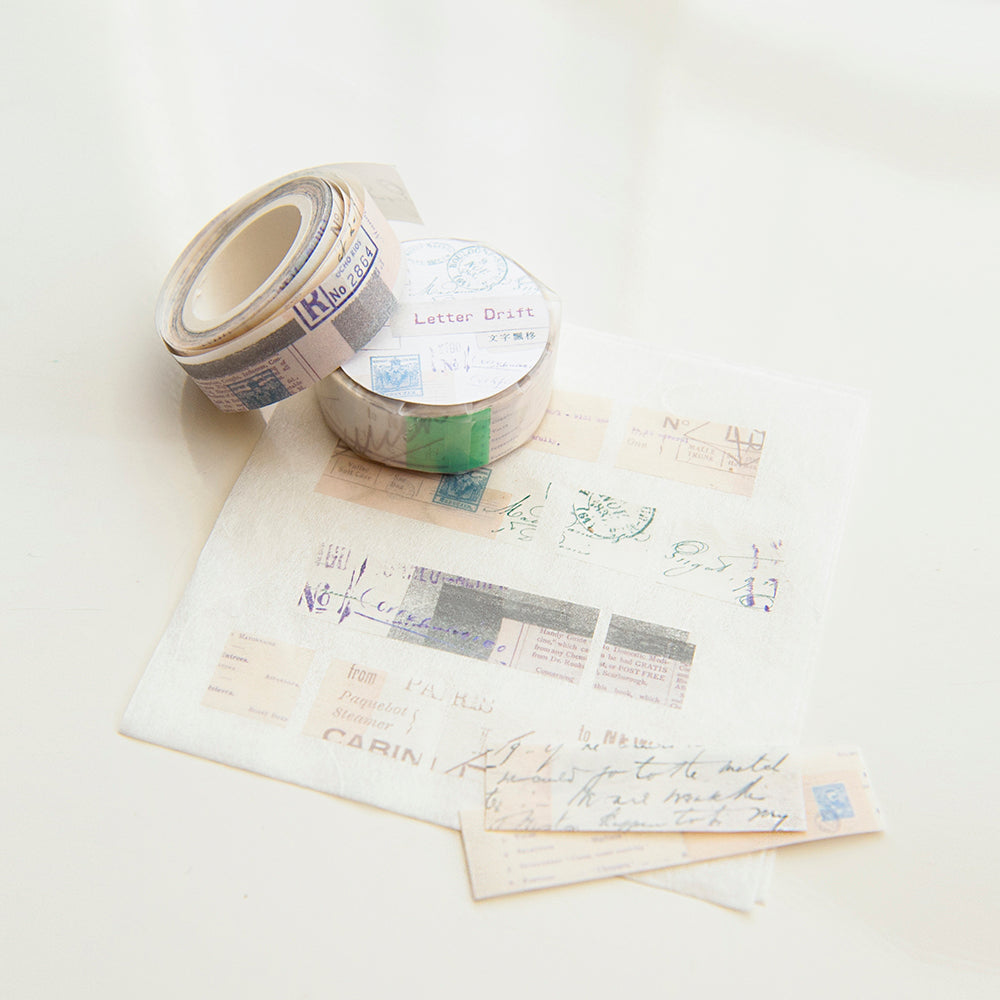 Two rolls of decorative tape on top of vintage letters with visible stamps.