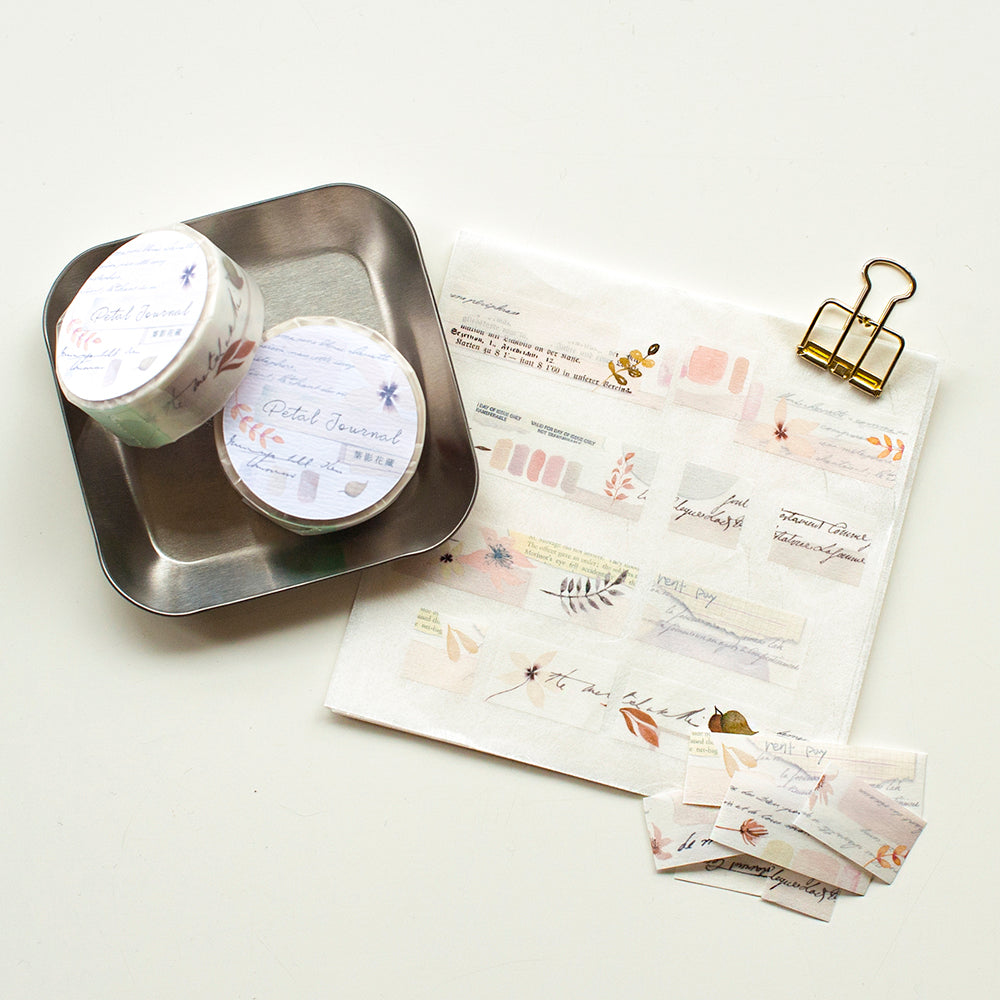 Two small containers on a metal tray with stationery items including envelopes and a letter on a white background.