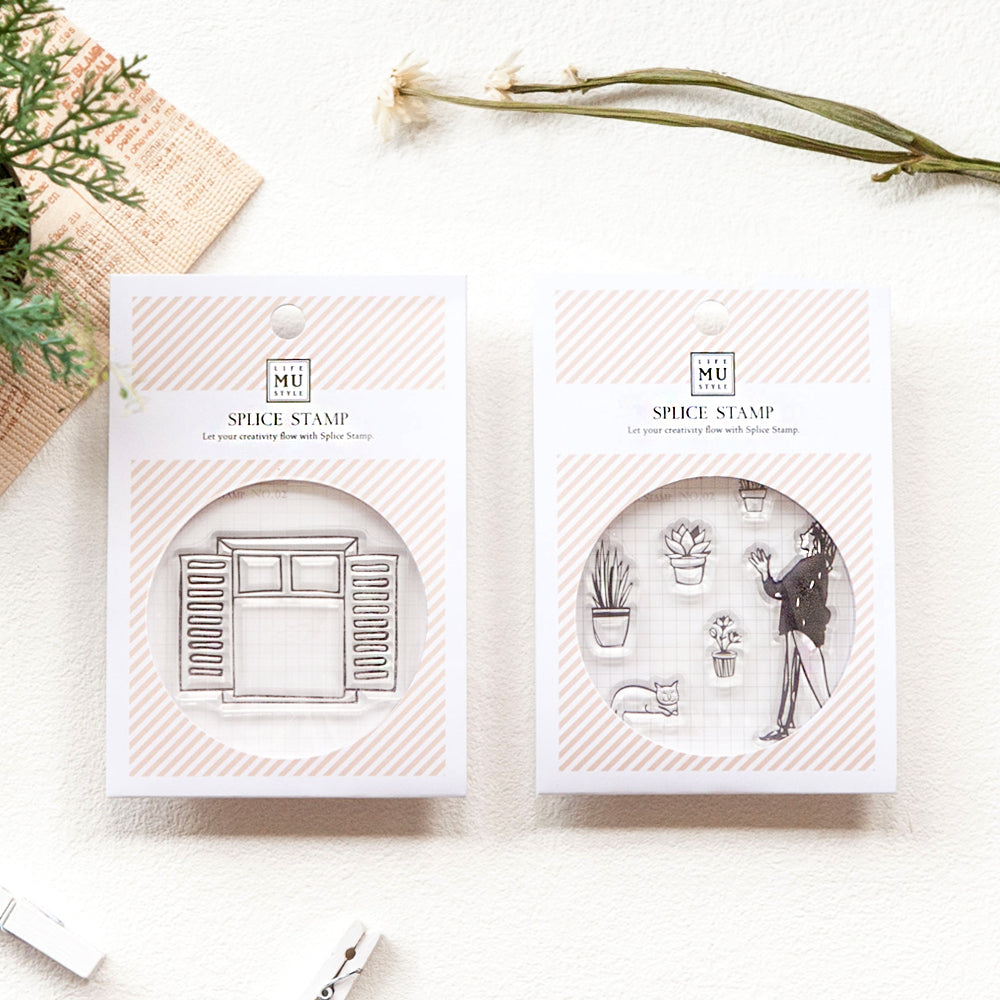 Two MU Spice Stamp sets on a white surface with plants and a plant pot in the background.