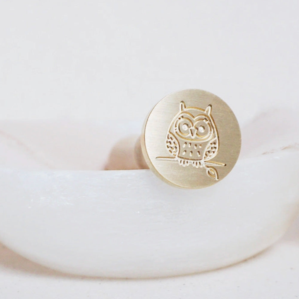 Gold wax seal head of an owl on a branch