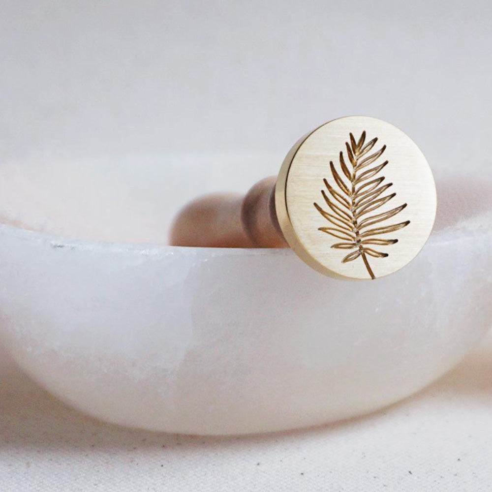 Gold wax seal head with a palm leaf design