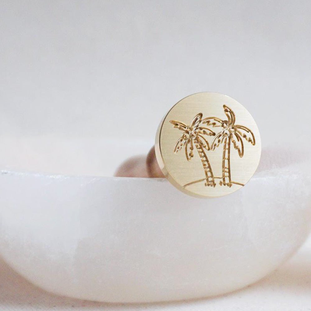 Gold wax seal head with palm trees on it