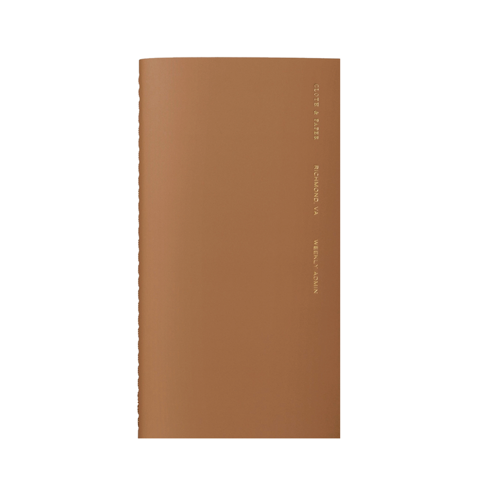 Brown notebook with gold foil lettering on the side.