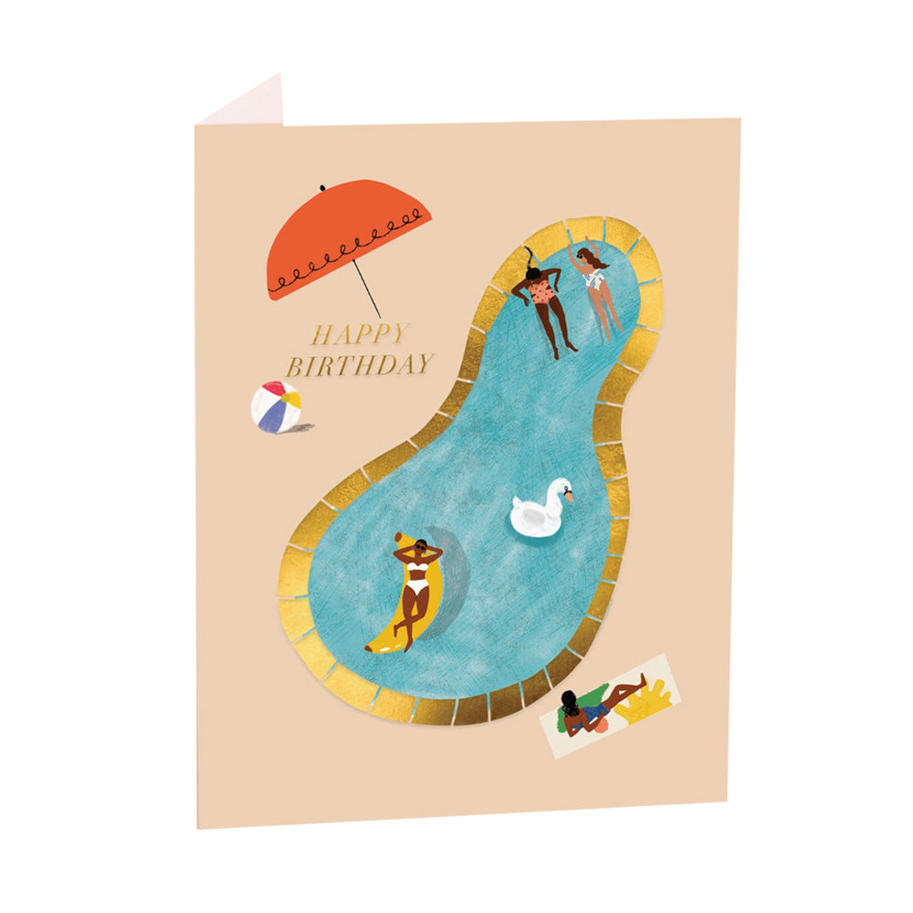 Birthday card with illustration of people by a pool, umbrella, and beach ball on a beige background with text reading "Happy Birthday" in gold foil.