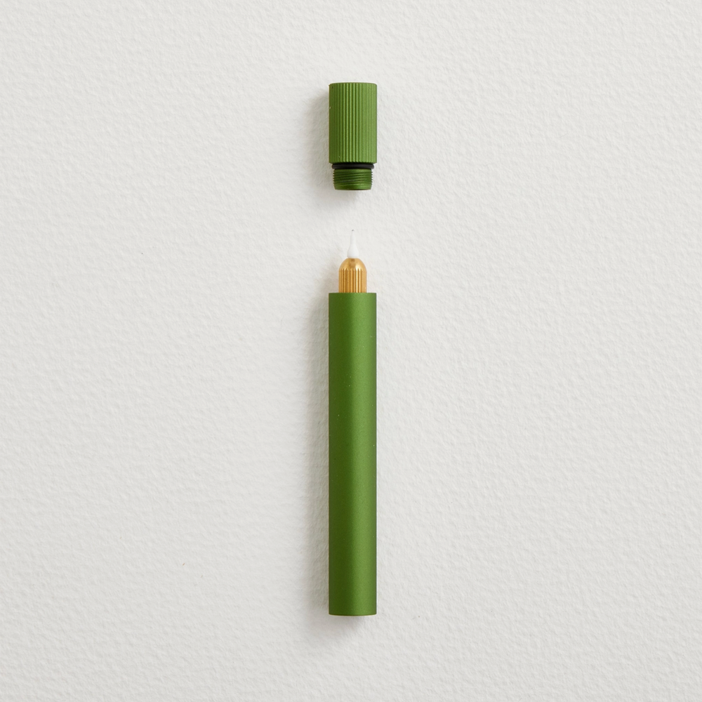 Green pen and cap on a light gray background