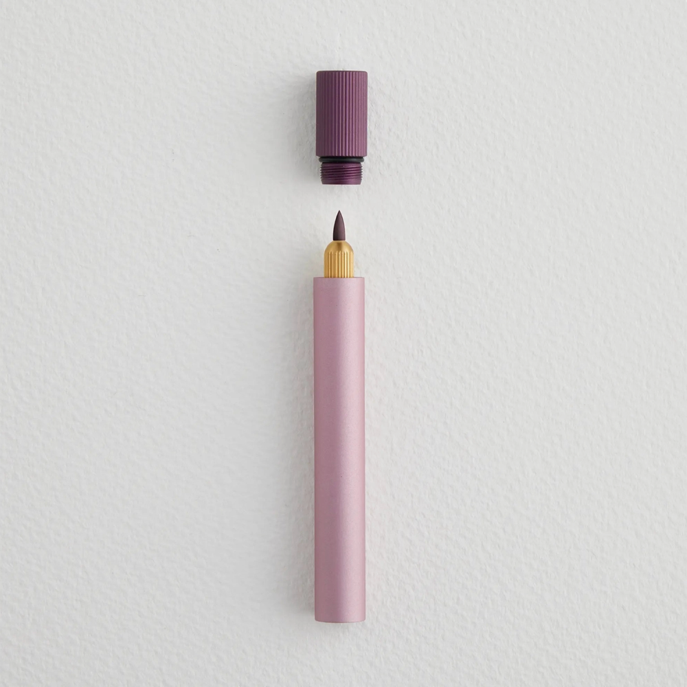 Pink pen with a purple cap on a light gray background