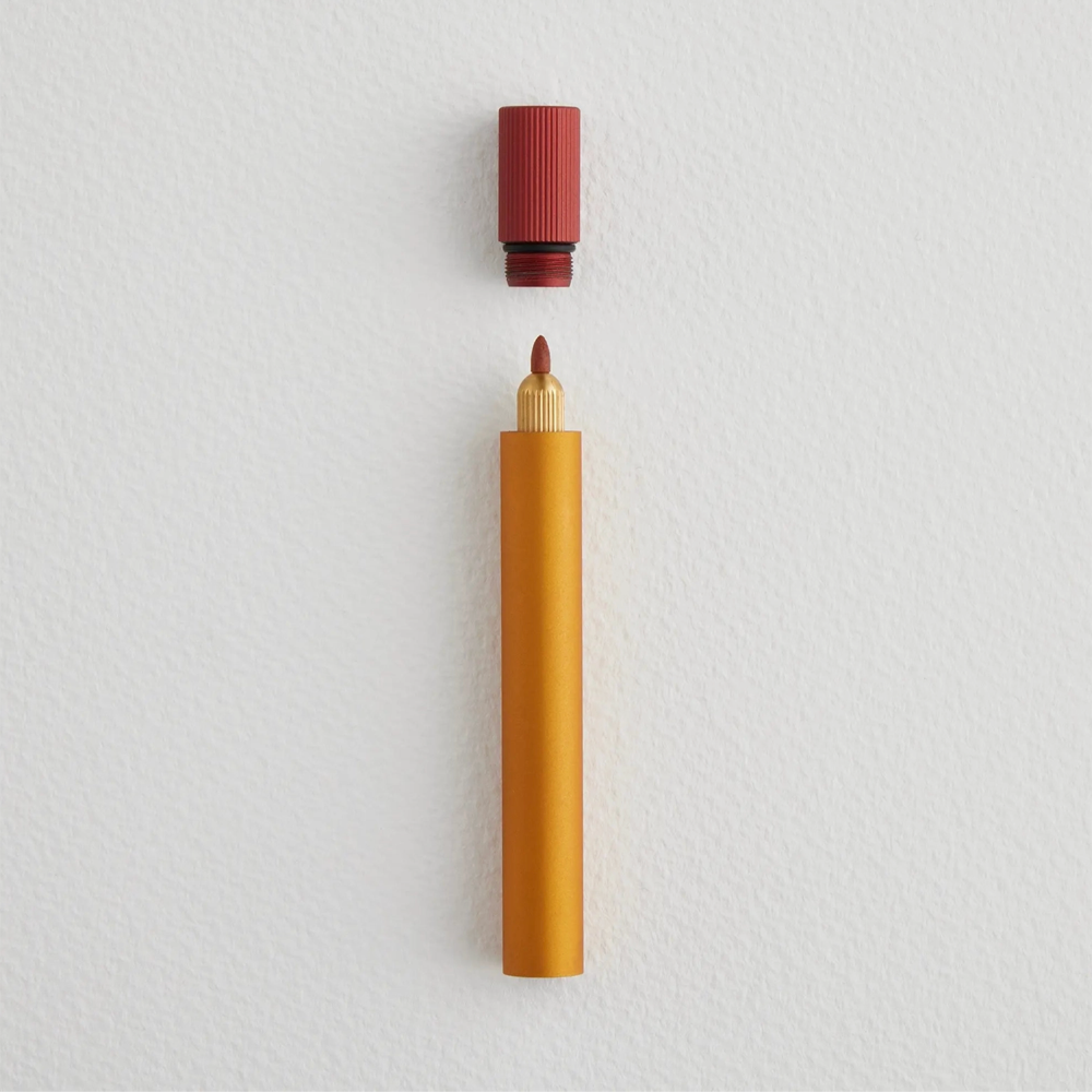 Orange pen with a red cap on a light gray background