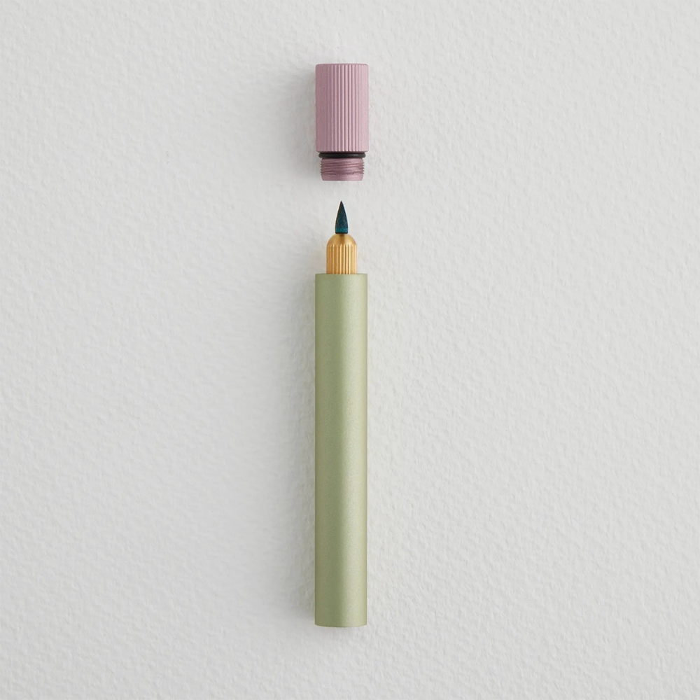 Green pen with a pink cap on a light gray background