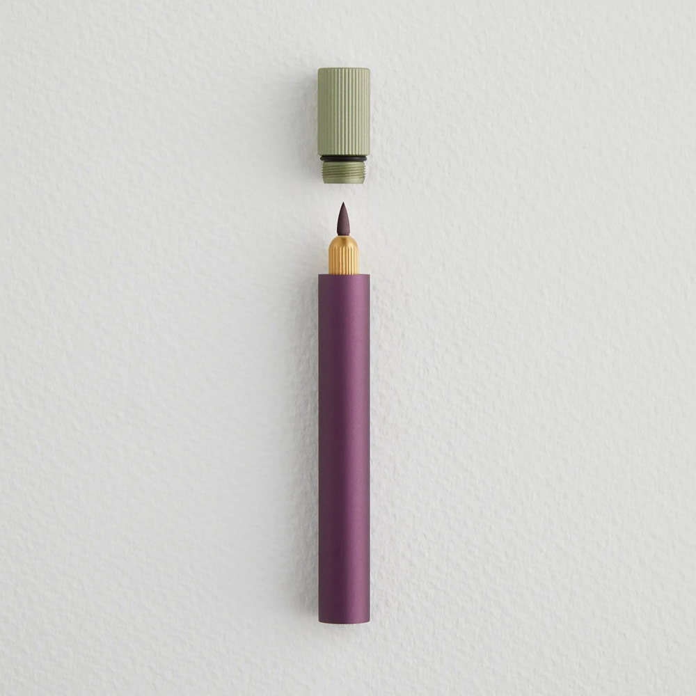 Purple pen with a light green cap on a light gray background