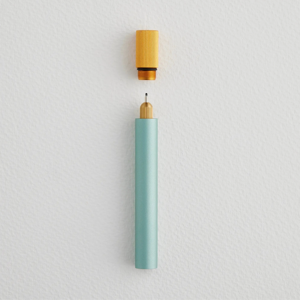 Mint blue pen with a golden yellow cap on a light gray background
