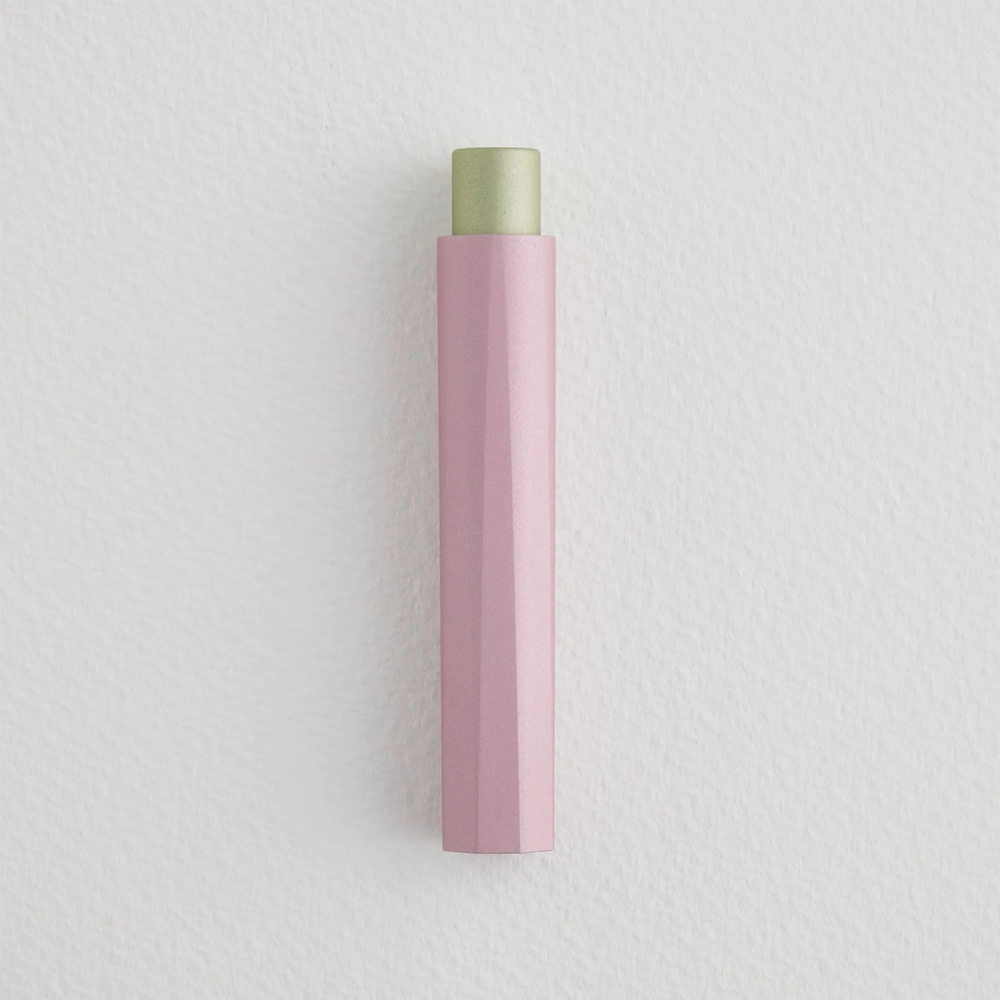 Capped pen with a peek of light green coming out of the top and a pink body with ridges.