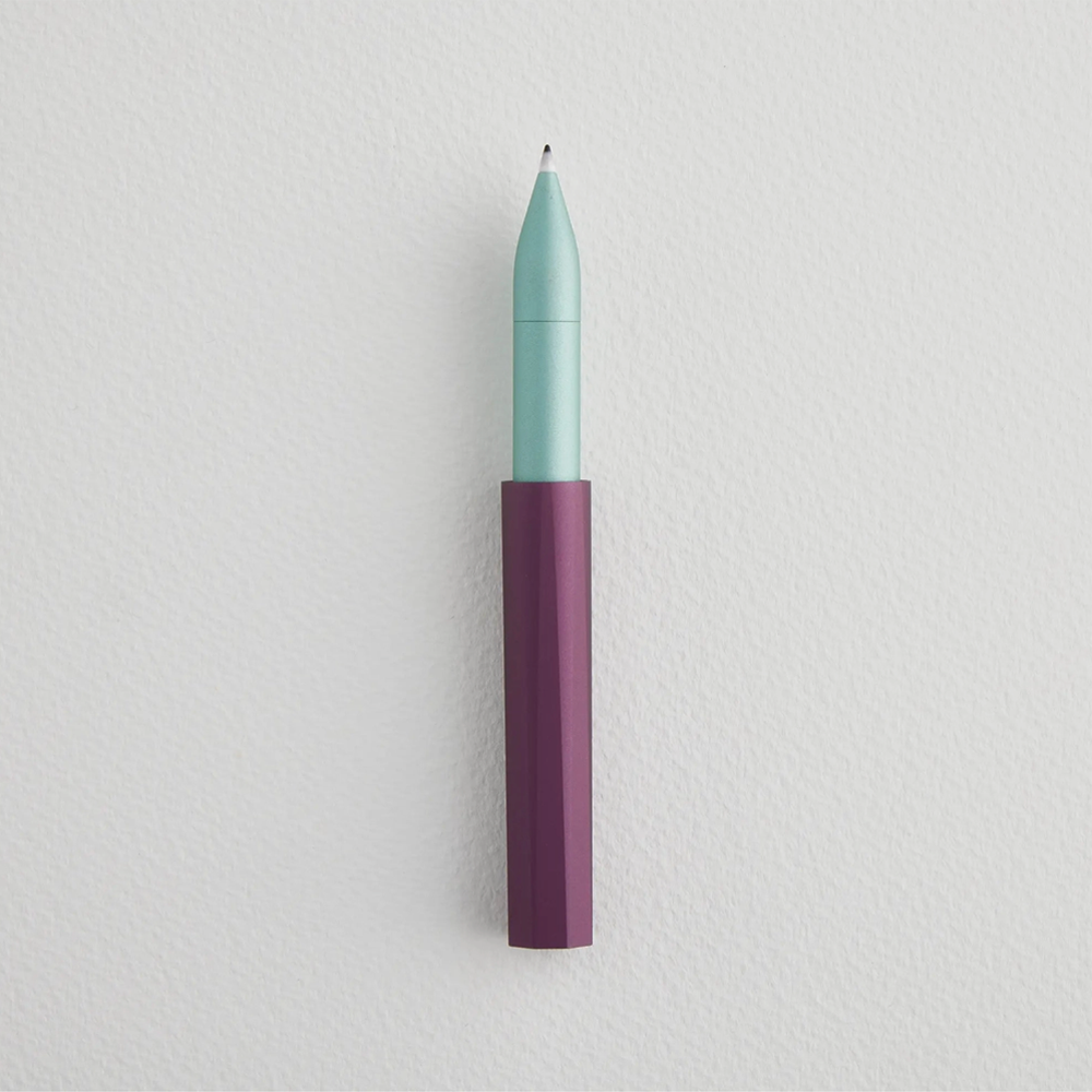 Uncapped pen with purple bottom and teal top with ink on the felt tip.